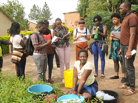 SIUE students take notes as they talk with community members during field work on their travel study in Uganda.