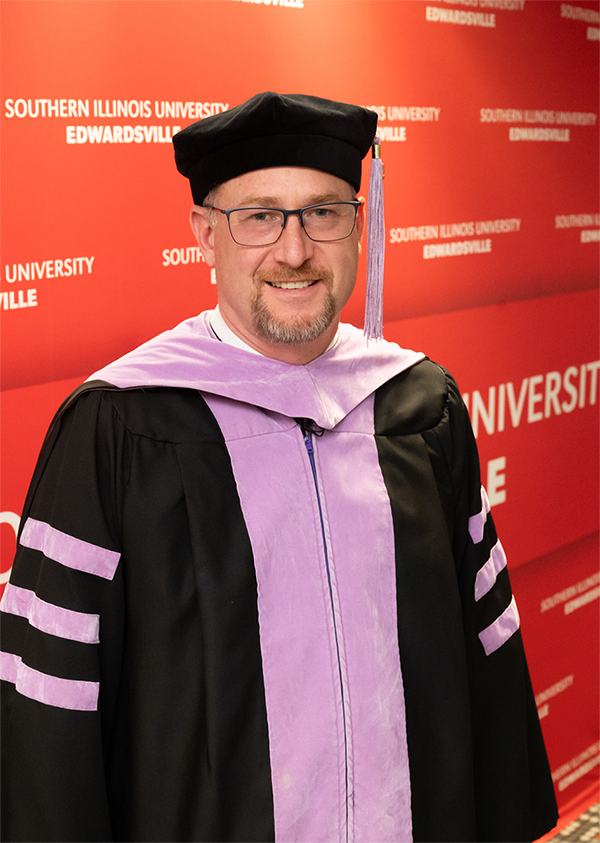 Dean Saulius Drukteinis standing in cap and gown