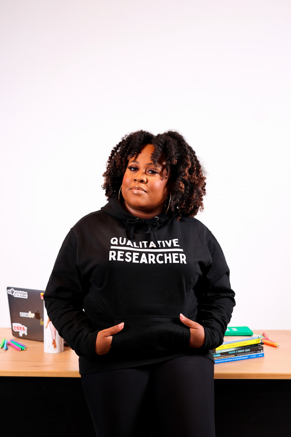 Portrait of Dr Candace Hall leaning against desk