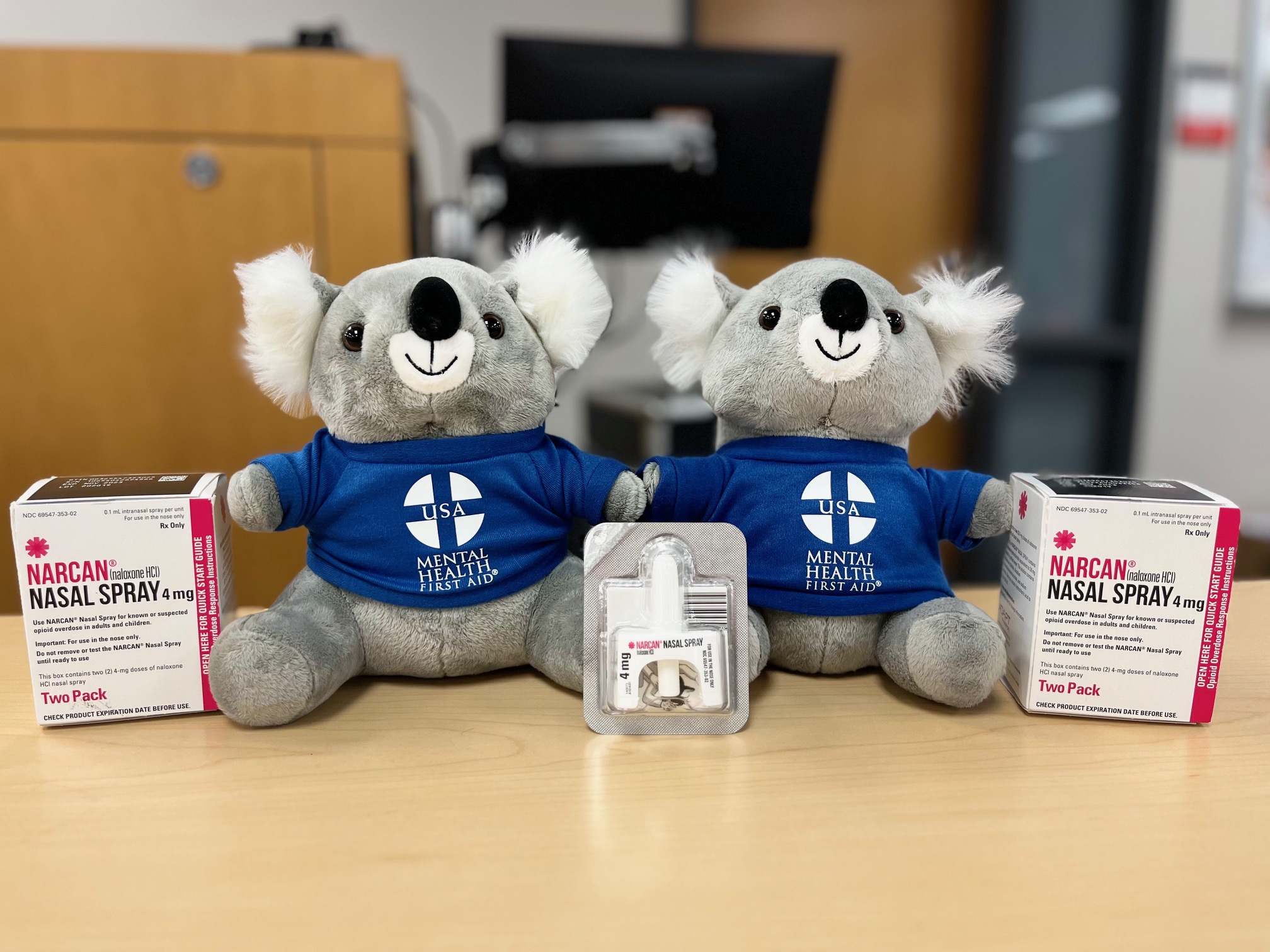 Stuffed animal bear and boxes of Narcan