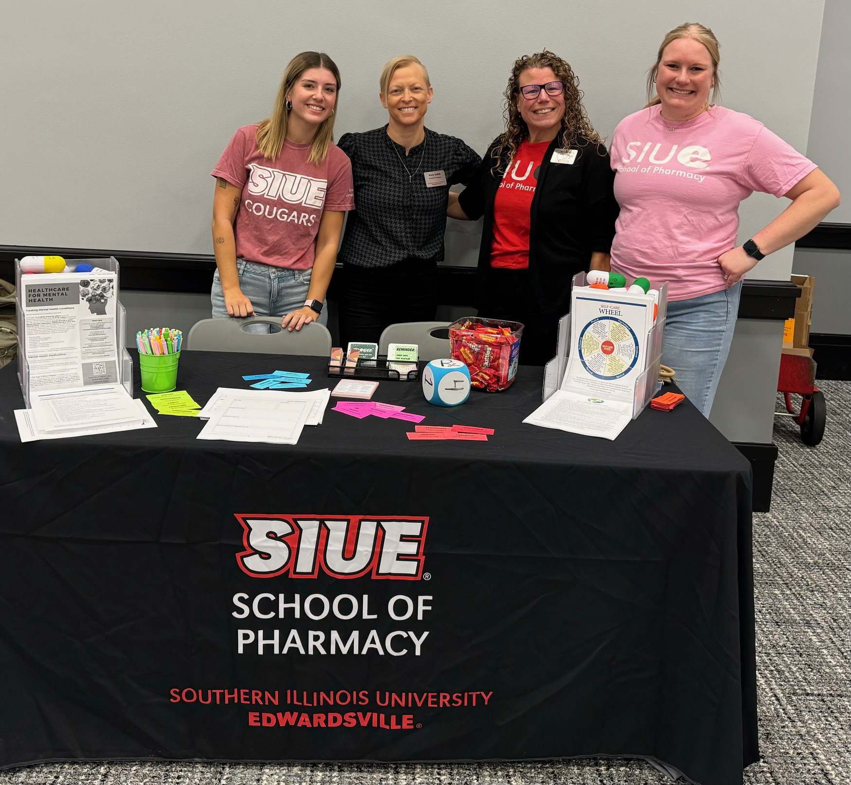 Four people smiling at a wellness booth